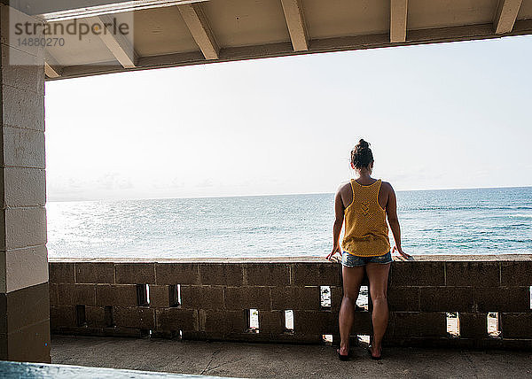 Frau schaut vom Balkon auf das Meer  Hookipa Beach  Maui  Hawaii