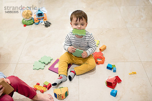 Kleiner Junge und Bruder spielen mit Spielzeug auf dem Boden