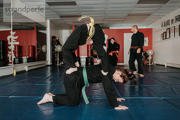 Trainer und Studenten üben Kampfsport im Studio
