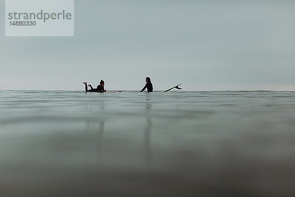 Junges Surferpaar mit Surfbrettern auf ruhiger  nebliger See  Ventura  Kalifornien  USA