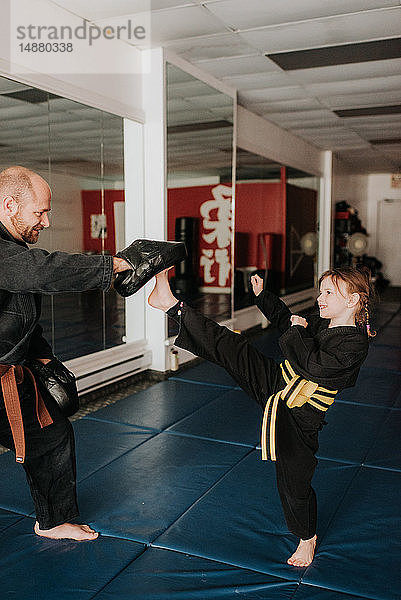 Trainer und Schüler üben Kickboxen im Studio