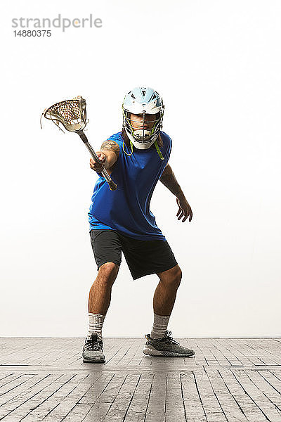 Mann modelliert Lacrosse-Helm und -Stock