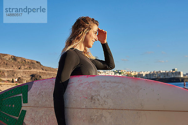 Surfer mit Surfbrett am Strand