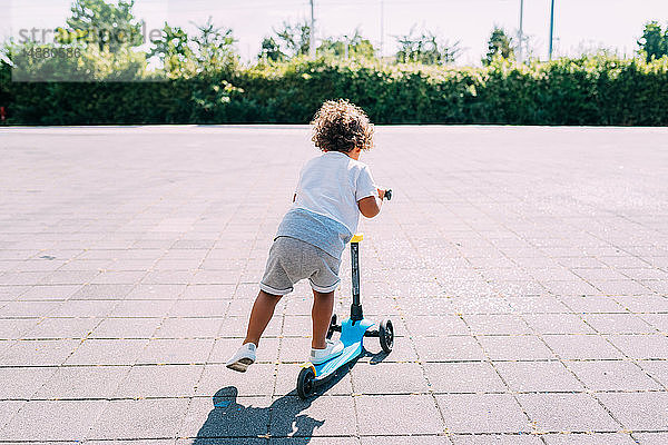 Kleinkind fährt Roller im Park