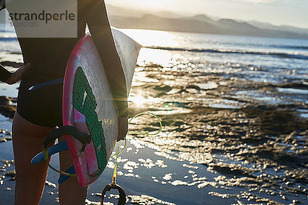 Surfer mit Surfbrett am Strand