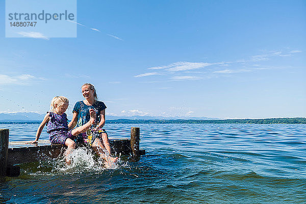 Mutter und Tochter kühlen Füße im Wasser  Starnberger See  Bayern  Deutschland