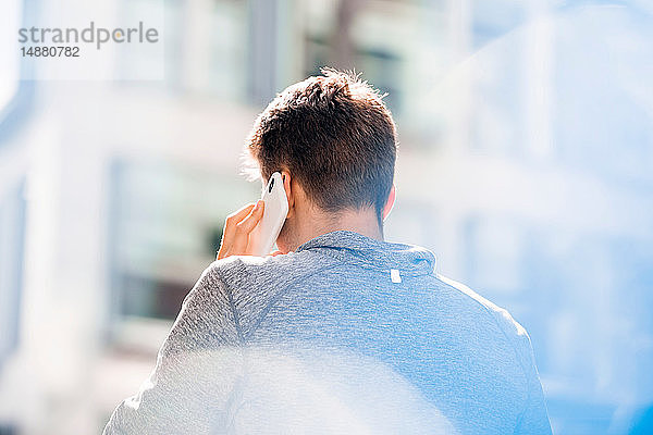 Junger Mann benutzt Smartphone in der Stadt