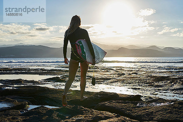 Surfer mit Surfbrett am Strand