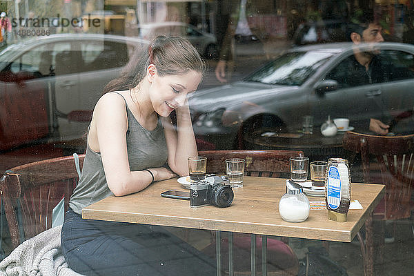 Junge Frau benutzt Smartphone im Café