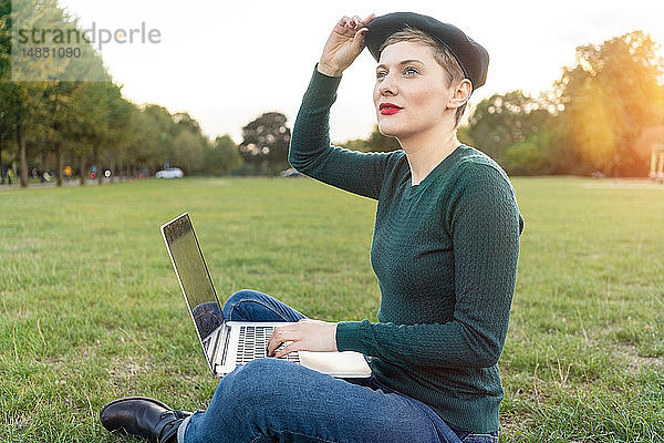 Frau benutzt Laptop im Park