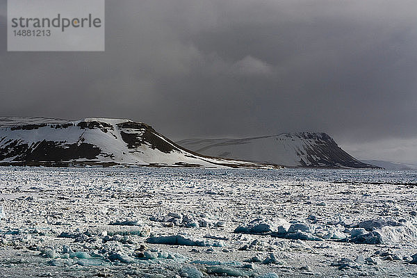 Meereis-Küstenlandschaft und Sturmwolken  Wahlenberg-Fjord  Nordaustlandet  Svalbard  Norwegen.