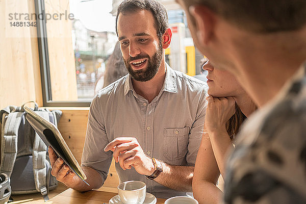 Treffen einer Gruppe von Unternehmern mit Kaffee und digitalem Tablett
