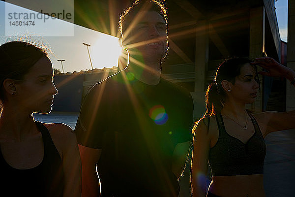 Freunde im Sportstadion bei Sonnenuntergang