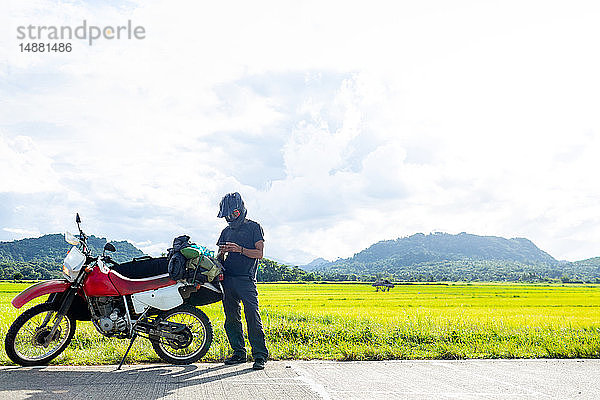 Motorradfahrer mit Zwischenstopp am Straßenrand  Camalaniugan  Cagayan  Philippinen