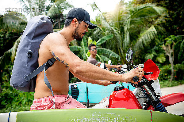 Motorradfahrer mit Surfbrett auf dem Fahrrad  Pagudpud  Ilocos Norte  Philippinen