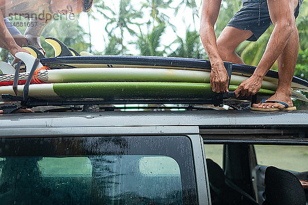 Männer laden Surfbretter auf den Autodachträger  Pagudpud  Ilocos Norte  Philippinen