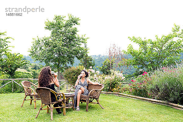 Frauen auf Korbstühlen im ländlichen Garten  Città della Pieve  Umbrien  Italien