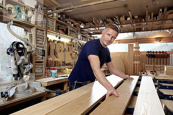 Handwerker  der in der Werkstatt Bretter aus Holz vorbereitet