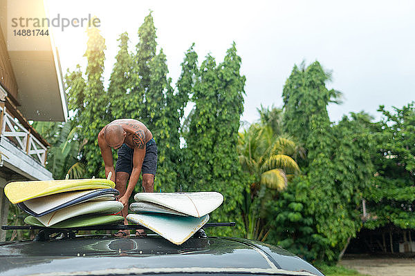 Mann lädt Surfbretter auf Autodachträger  Pagudpud  Ilocos Norte  Philippinen