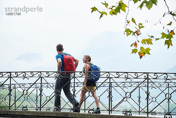 Mann und junge Frau beim Spaziergang über den Flusssteg  Porträt  Annecy  Rhône-Alpes  Frankreich