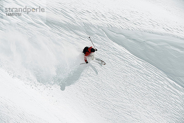 Männlicher Skifahrer beim Skifahren am Berghang  Hochwinkelansicht  Alpe-d'Huez  Rhône-Alpes  Frankreich