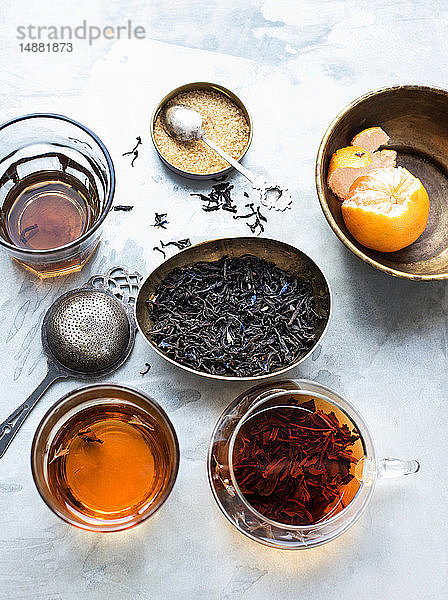 Tasse und Kanne Tee mit Zucker und Mandarine