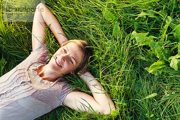 Frau liegt im Gras auf dem Land