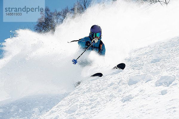 Männlicher Skifahrer schwenkt beim Skifahren den Berg hinunter  Alpe-d'Huez  Rhône-Alpes  Frankreich