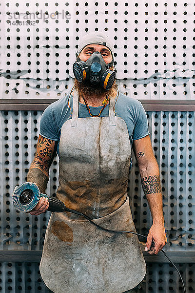 Axtmacherin mit Maske in der Werkstatt