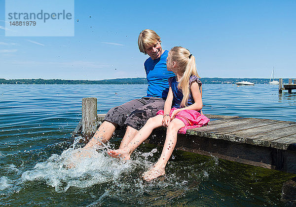 Vater und Tochter kühlen Füße im Wasser  Starnberger See  Bayern  Deutschland