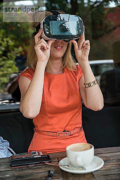 Frau benutzt Virtual-Reality-Headset im Café