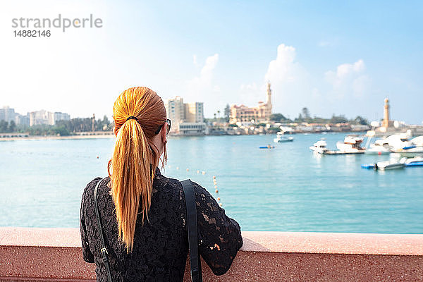 Touristin mit roten Haaren  Blick über das Meer auf den Palast von Montaza  Rückansicht  Alexandria  Ägypten