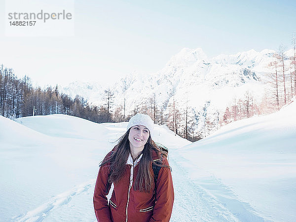 Junge Frau mit Strickmütze in schneebedeckter Landschaft  Alpe Ciamporino  Piemont  Italien