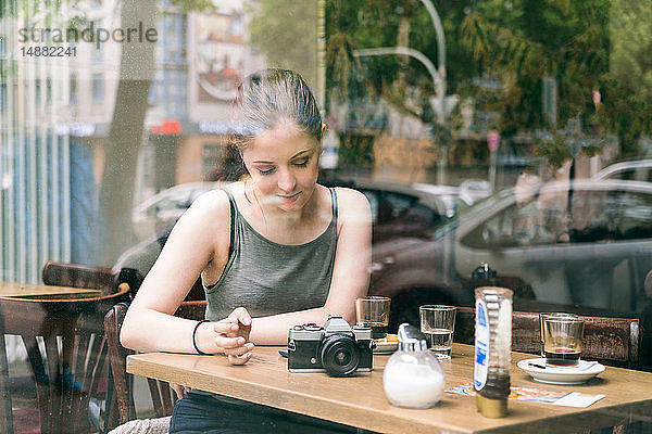 Junge Frau benutzt Smartphone im Café