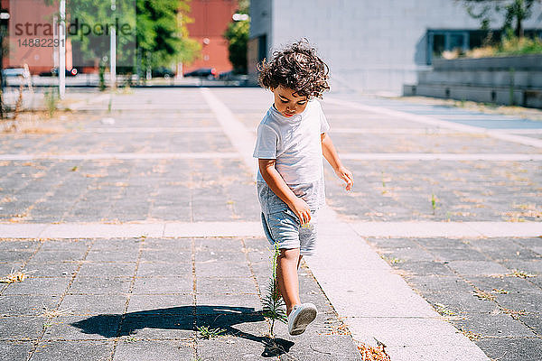 Kleinkind spielt mit Schatten im Park