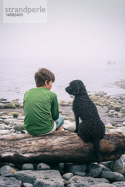 Junge und Hund genießen das Meer