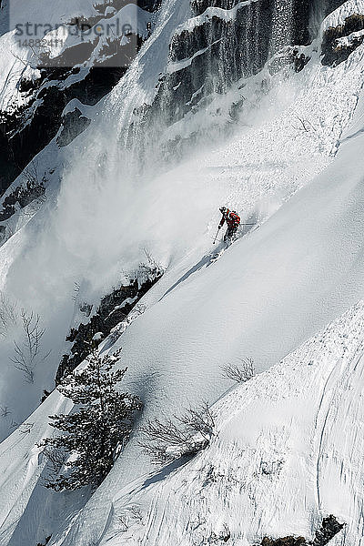 Männlicher Skiläufer rast den zerklüfteten vertikalen Berghang hinunter  Alpe-d'Huez  Rhône-Alpes  Frankreich