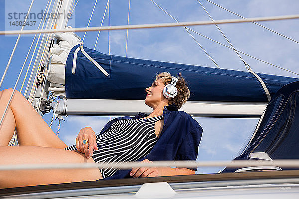 Reife Frau beim Sonnenbaden auf einem Segelboot auf dem Chiemsee  Bayern  Deutschland