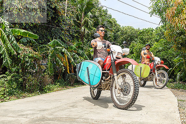 Motorradfahrer mit Surfbrett auf dem Fahrrad  Pagudpud  Ilocos Norte  Philippinen