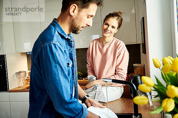 Ehepaar beim Sprechen und Abwaschen in der Küche