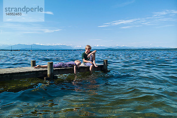 Geschwister entspannen am Pier  Starnberger See  Bayern  Deutschland