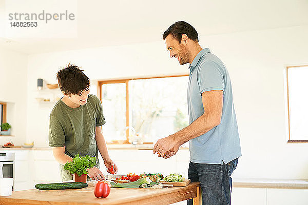 Junge und sein Vater bereiten das Essen an der Küchentheke