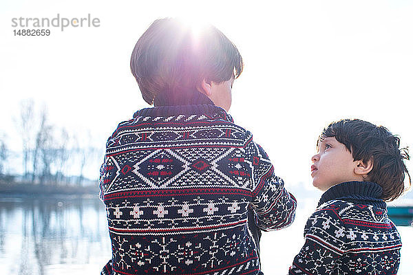 Junge und kleiner Bruder im passenden Pullover im Gespräch am Comer See  Comer See  Lecco  Lombardei  Italien