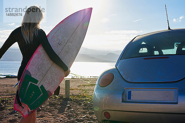 Surfer mit Surfbrett am Strand