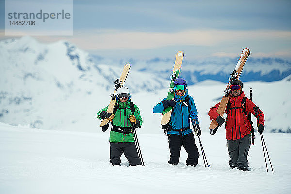 Landschaft mit drei männlichen Skifahrern mit Skiern  Porträt  Alpe-d'Huez  Rhône-Alpes  Frankreich