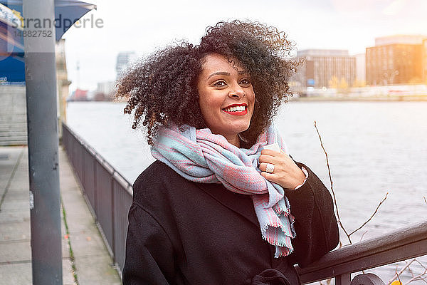 Mittelgroße erwachsene Frau mit Schal am Ufer der Spree  Berlin  Deutschland
