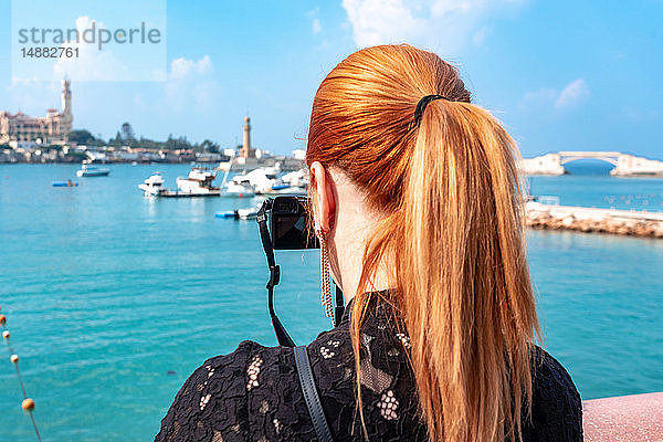 Touristin mit roten Haaren fotografiert über dem Meer in Richtung Montaza-Palast  Rückansicht  Alexandria  Ägypten