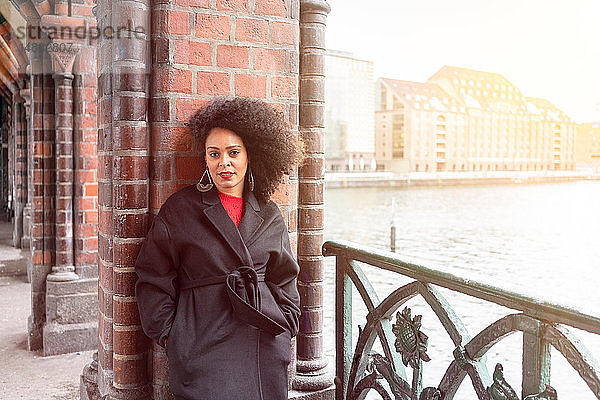 Mittlere erwachsene Frau in stilvollem Mantel auf der Oberbaumbrücke  Porträt  Berlin  Deutschland