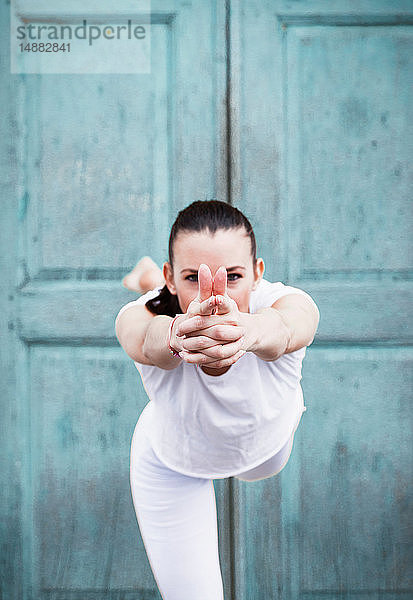 Yoga praktizierende Frau  auf einem Bein vor der Tür  Porträt