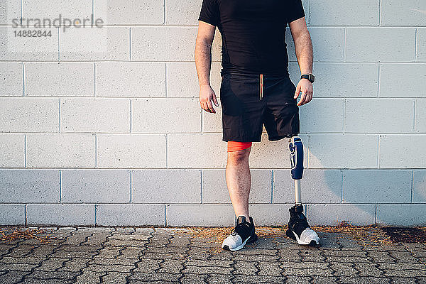 Mann mit an der Wand lehnender Beinprothese